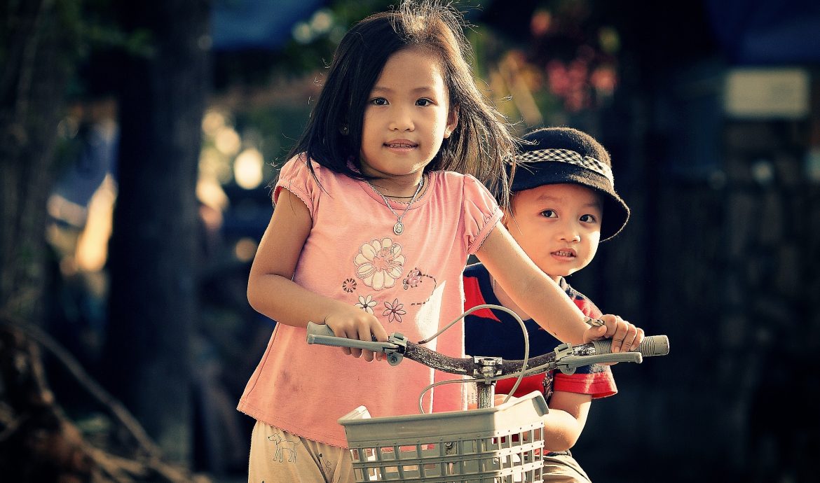 Barn balanserar en cykel